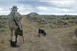 © Colby - Camouflaged hunter with rifle and tracking dog
