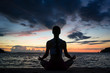 © Kzenon - Full length rear view of a fit woman sitting in lotus position while practicing yoga on the beach at twilight during summer vacation in Flores Island, Indonesia