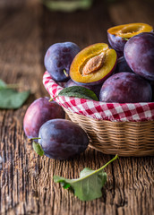 Wall Mural - Plums. Fresh juicy plums in a bowl on a wooden or concrete board.