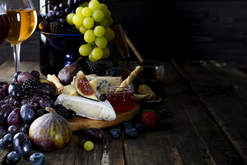 Grape, cheese, figs and honey with a glasses of white wine