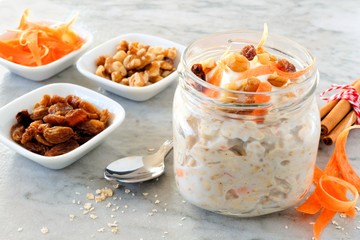 Wall Mural - carrot cake overnight oats with nuts and raisins in a mason jar, still life on marble background