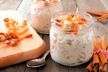 Wall Mural - carrot cake overnight oats with nuts and raisins in mason jars, still life on a rustic wood backgrou