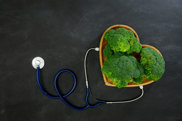 Wall Mural - green broccoli vegetable in wooden plate as heart