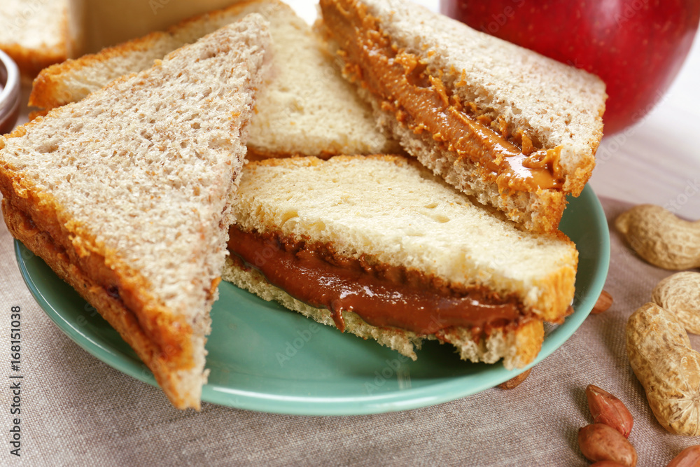 Tasty sandwiches with peanut butter on plate, closeup