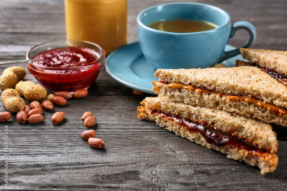Tasty sandwiches with peanut butter and jam for breakfast on table