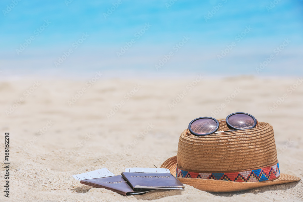 Hat, sunglasses and documents on sea beach. Summer vacation concept