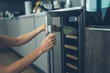 © LoloStock - Woman getting bottle of wine from cooler