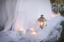 Lanterns With Candles On White Silk Background