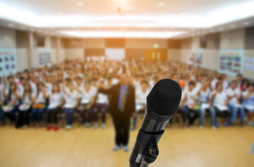 Microphone over the Abstract blurred photo of conference hall or seminar room with attendee background,Small Business training concept