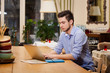© aemstock - Young guy working on laptop in the Italian style kitchen