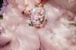 Rich wedding bouquet of peonies lies on bride's knees