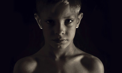 Young athletic boy on a dark background