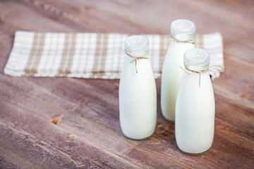 bottles of milk on a wooden rustic table.