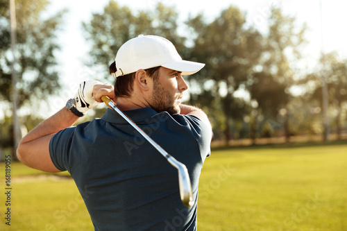 Fotografia, Obraz Close up of a young concentrated man shooting golf ball