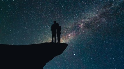 Wall Mural - The couple stand on the montain on the starry background. time lapse, night time