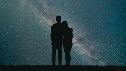 Wall Mural - The man and woman look to meteor shower in the sky. time lapse