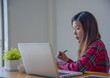 © EKKAPON - Business woman working at office with laptop, tablet and graph data documents on his desk.