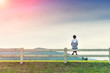 © SuparakFOTO - Young woman sitting on fence and sunlight