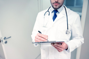 Wall Mural - close up of doctor with clipboard at hospital