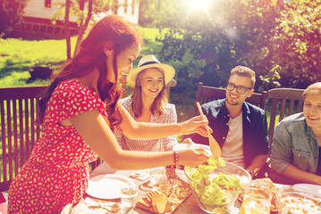 happy friends having dinner at summer garden party