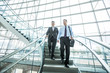 © Mike Kemp/Blend Images - Smiling Mixed Race businessmen descending staircase