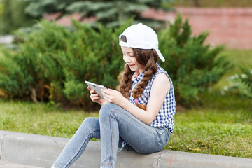 Wall Mural - A cute girl using pad siting on the grass