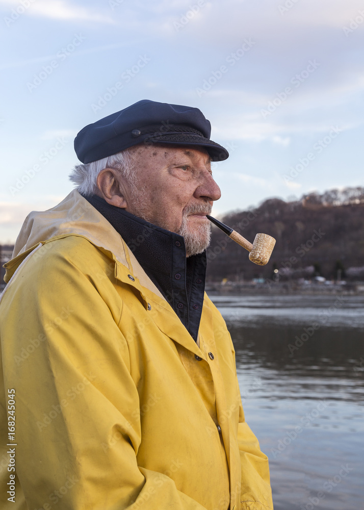 Senior fisherman smoking pipe Stock Photo