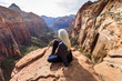 © Steve Smith/Blend Images - Caucasian woman sitting on rock admiring scenic view of rock formations