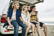 © Peathegee Inc/Blend Images - Caucasian friends sitting in car hatch at beach