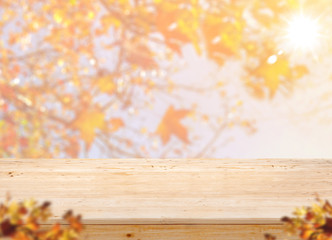 Aufkleber - Empty wood table top (food stand) with blur maple leaf with sunlight and blurred maple leaf at foreground,Autumn backgorund,Mock up for display or montage of product,banner for advertise on online