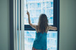 © LoloStock - Woman closing blinds in apartment