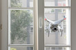 Flying white drone spying through window