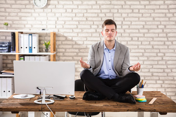 Businessman Meditating In Office