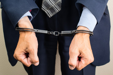 arrested businessman in handcuffs. Businessman bribetaker or briber. Concept of fraud, detention, crime and bribery