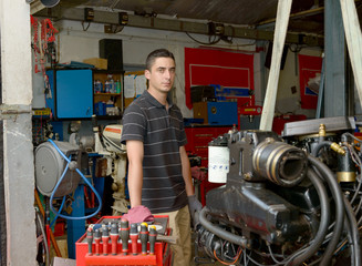 Wall Mural - Portrait of a young mechanic in his workshop