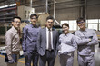 © Blue Jean Images - Confident businessman and engineering team in the factory