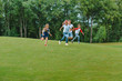 © LIGHTFIELD STUDIOS - Happy multiethnic kids playing together and running on green grass in park