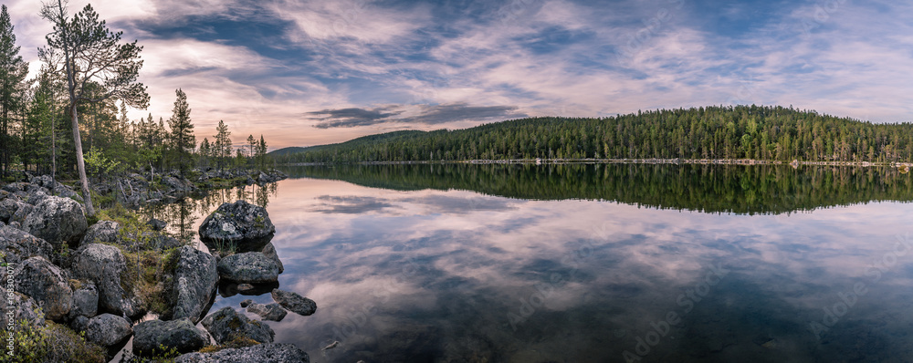 Panorama of calm lake at Lapland in midnight sun time. Rocks in front. - obrazy, fototapety, plakaty 