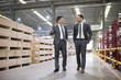 © Blue Jean Images - Two businessmen talking while walking in the factory