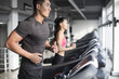 © Blue Jean Images - Young couple exercising on treadmills in gym