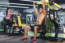 Young Man And Woman Exercising In Gym