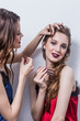 © liliyabatyrova - Makeup artist paints the eyebrow of a beautiful girl, blonde, brown eyeliner, she grins and holds her hand on the makeup, white background, hair, professional makeup, Studio