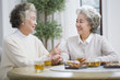 © Blue Jean Images - Happy senior women talking and drinking tea
