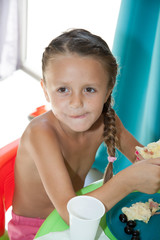 cute ten girl in summer day eat in kitchen house