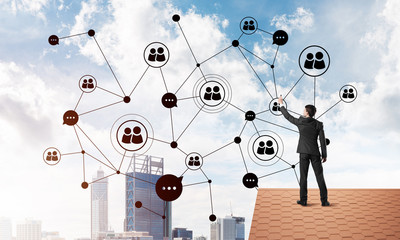 businessman on house roof presenting networking and connection concept. mixed media