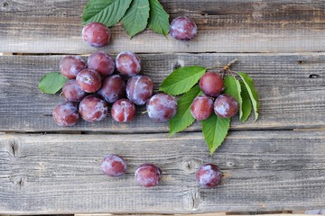 Delicious fresh plums on wooden background view  