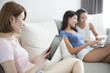 © Blue Jean Images - Best female friends surfing the net at home