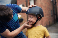 Father Putting On Sons Safety Helmet