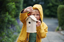 Child Holding A Birdhouse