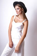 © yuliachupina - Girl in white clothes and black hat posing in studio on white background.